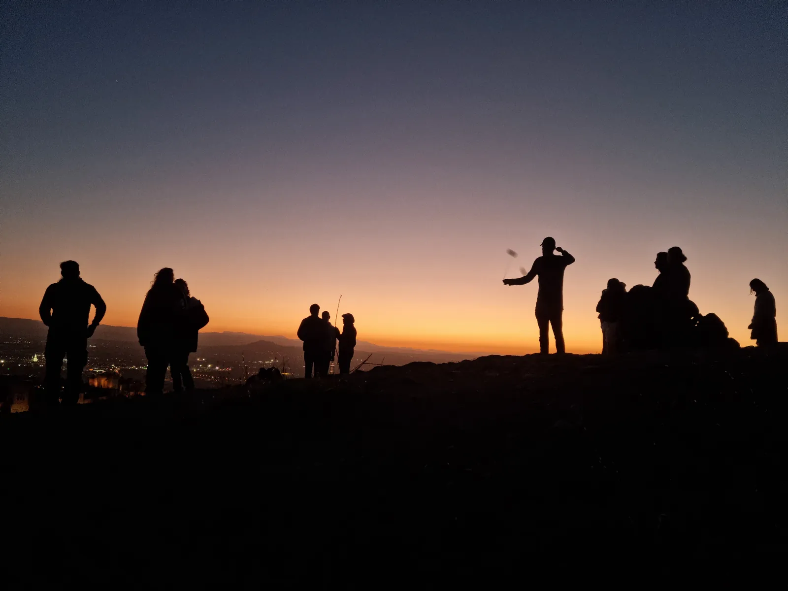 Brothers gathered on a hilltop at sunset