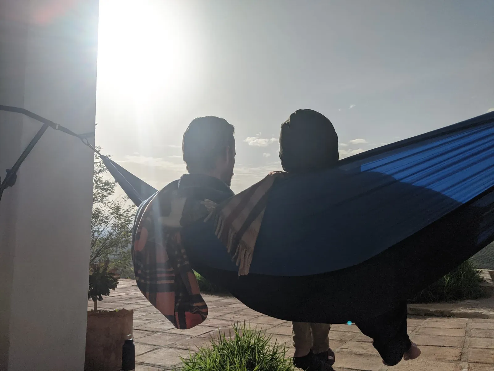 Two men resting together in a hammock in the sun