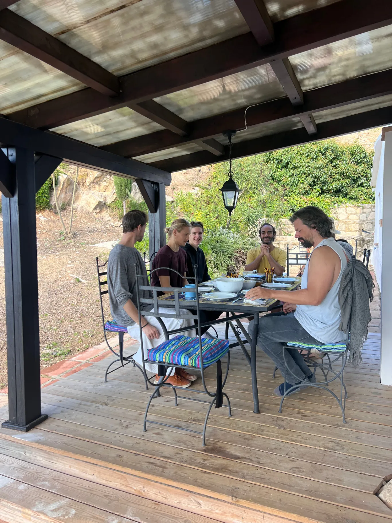 Brothers sharing a meal under the pergola