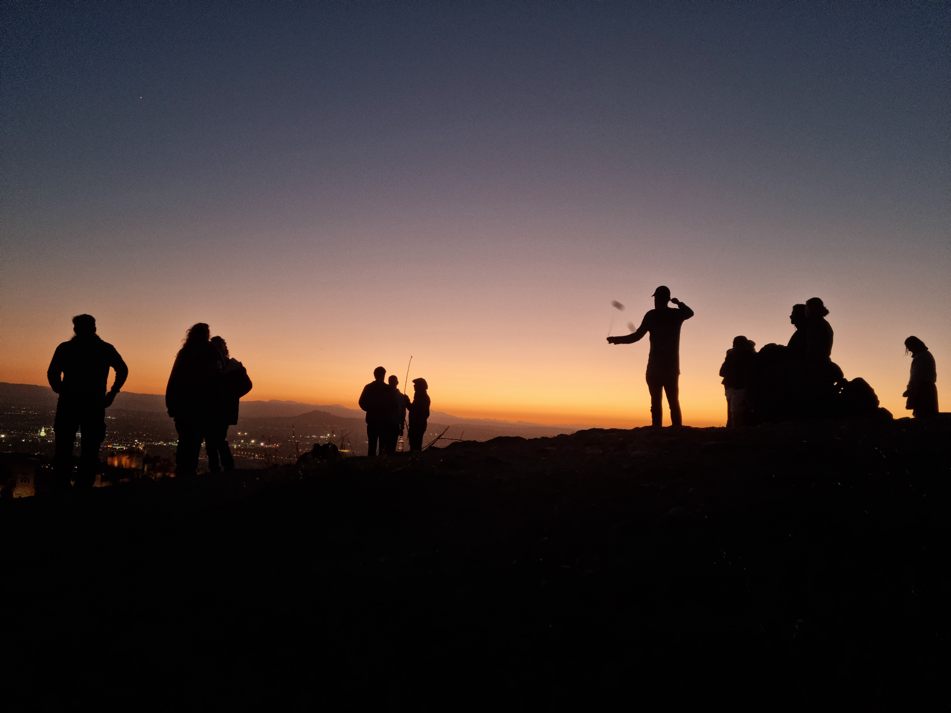 Brothers gathered on a hilltop at sunset